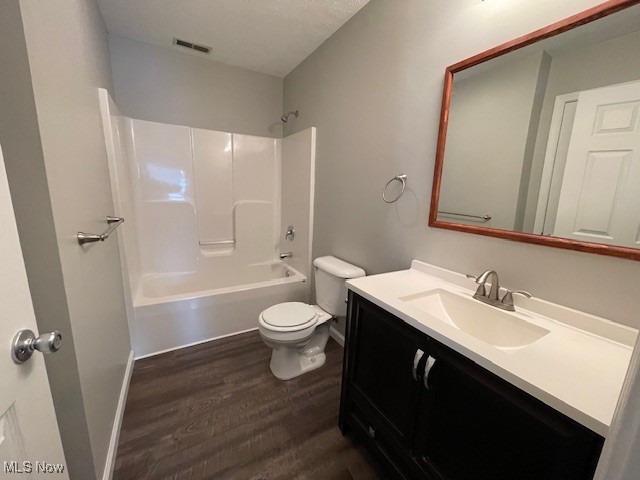 5514 Linn Road Amherst, OH 44001 - Photo 8 of 16 Full bathroom featuring shower / bathing tub combination, hardwood / wood-style floors, a textured ceiling, toilet, and vanity