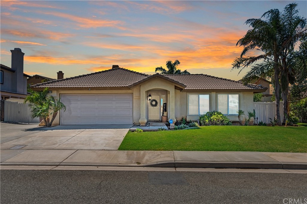 a front view of a house with a garden and yard