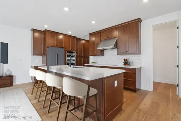 a kitchen with stainless steel appliances granite countertop a table chairs sink and cabinets