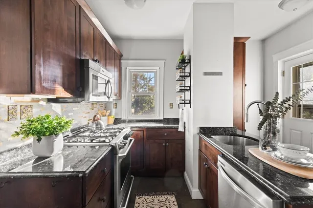 a kitchen with stainless steel appliances granite countertop a sink stove and cabinets