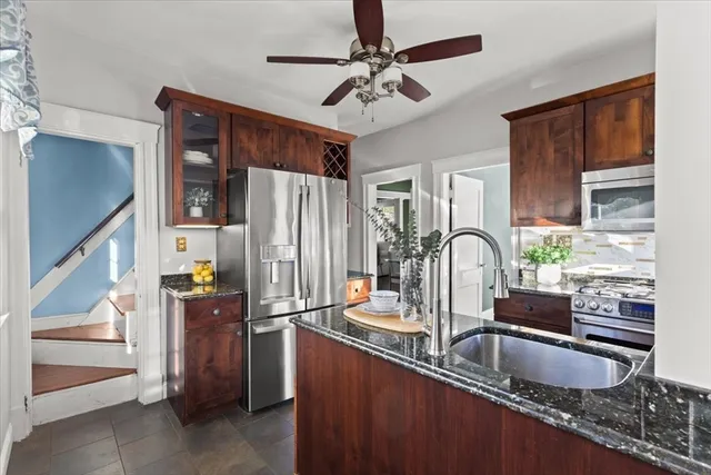 a kitchen with stainless steel appliances granite countertop a sink refrigerator and microwave