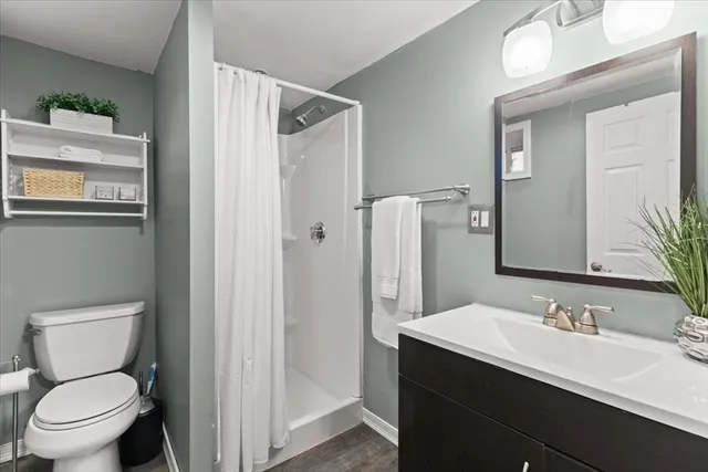 a bathroom with a granite countertop sink toilet and shower