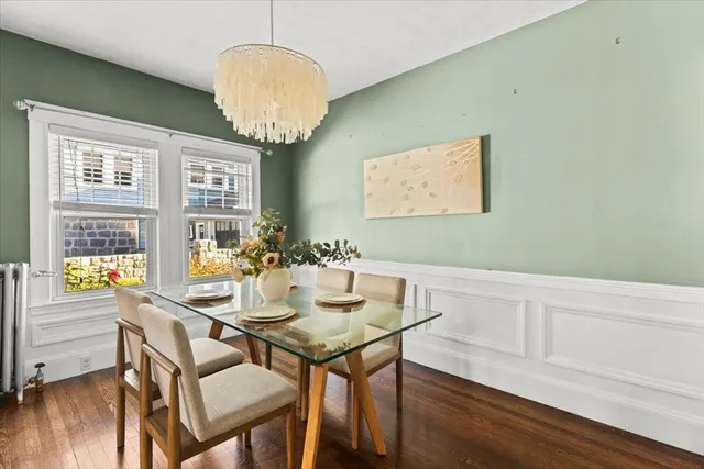 a view of a dining room with furniture a chandelier and wooden floor