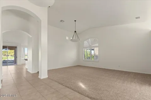 a view of a hallway with windows and chandelier