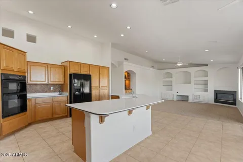 a open kitchen with stainless steel appliances granite countertop a stove a sink and a refrigerator with the cabinets