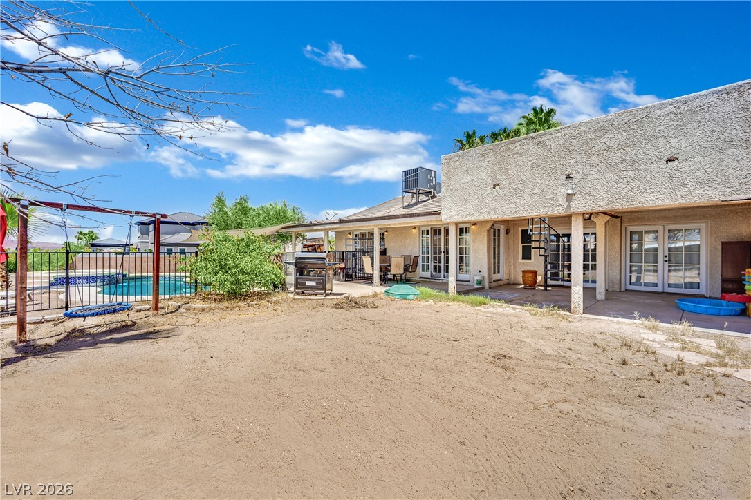 420 North Racetrack Road Henderson, NV 89015 - Photo 41 of 52 An inviting backyard awaits, featuring a fenced pool and a covered patio for outdoor enjoyment.