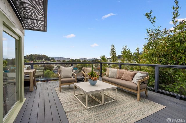 a terrace with outdoor seating and trees