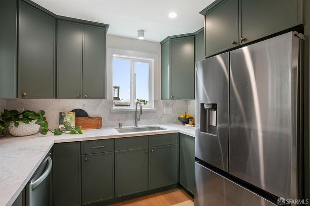 a kitchen with stainless steel appliances a refrigerator sink and stove