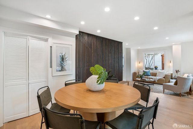 a dining room with furniture a chandelier and wooden floor