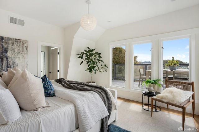 a bedroom with a bed and large windows