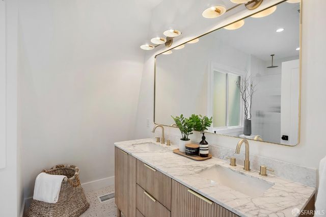 a bathroom with a granite countertop sink and a mirror