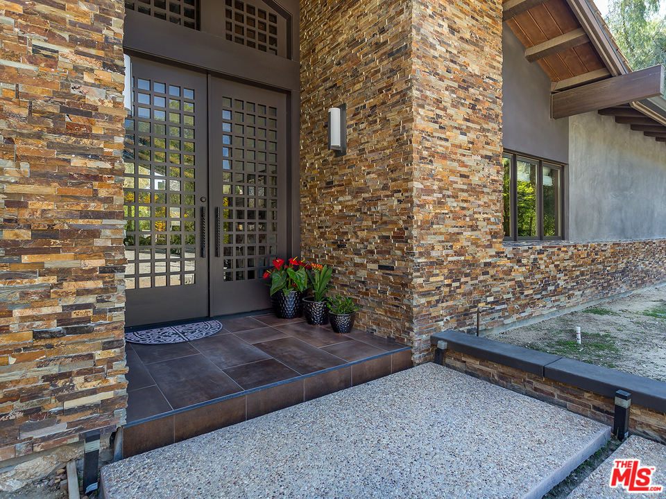 24754 Robert Guy Road Hidden Hills, CA 91302 - Photo 2 of 18 a view of a backyard with plants and brick wall
