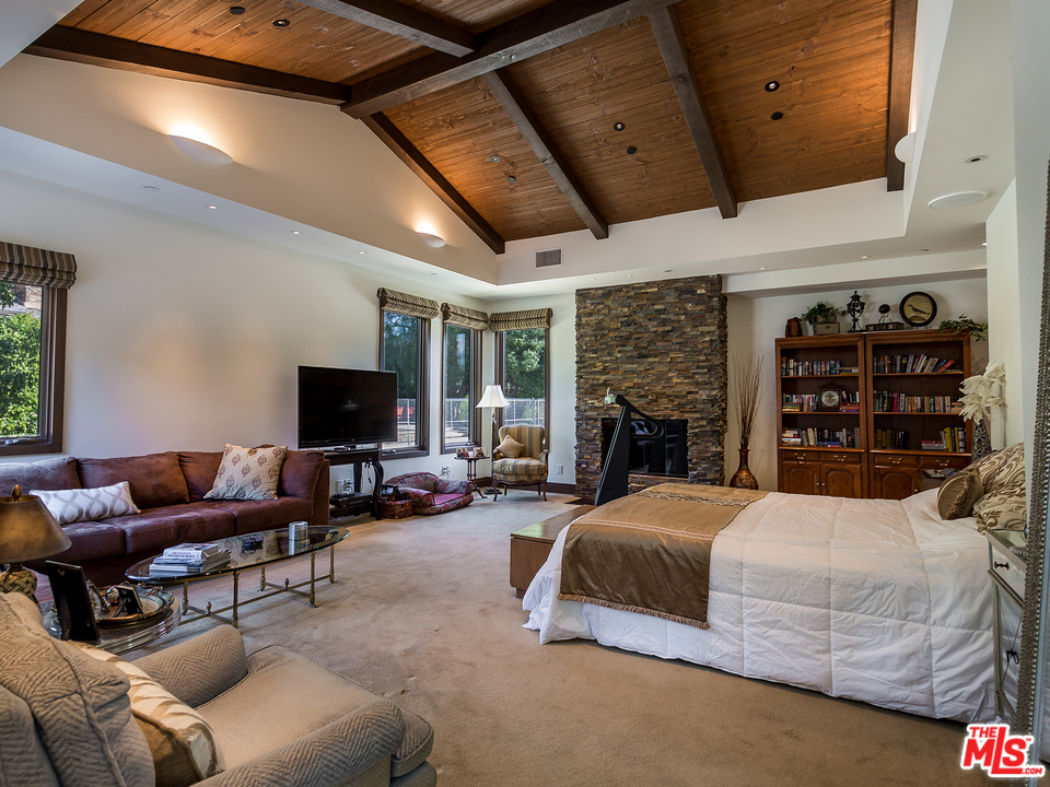 24754 Robert Guy Road Hidden Hills, CA 91302 - Photo 13 of 18 a bedroom with a bed a couch and a flat screen tv