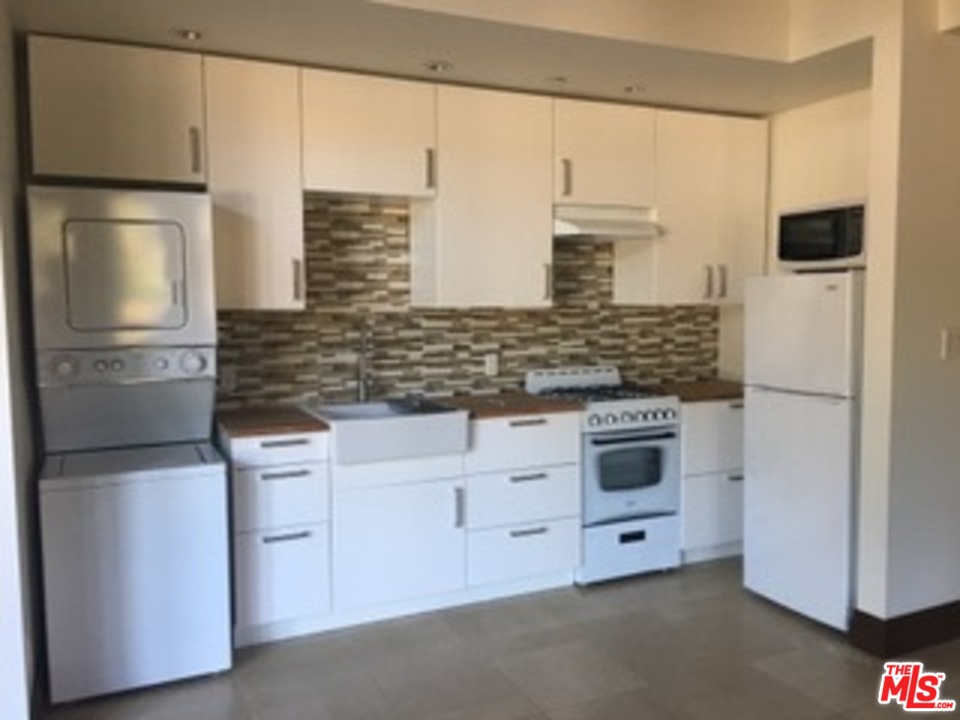 24754 Robert Guy Road Hidden Hills, CA 91302 - Photo 17 of 18 a kitchen with stainless steel appliances white cabinets and a refrigerator