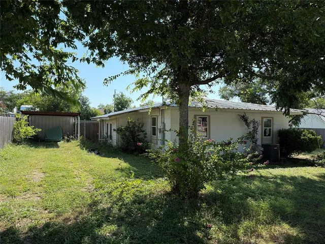a backyard of a house with plants and tree
