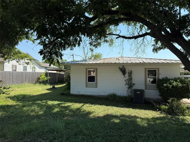 a view of backyard of house with green space