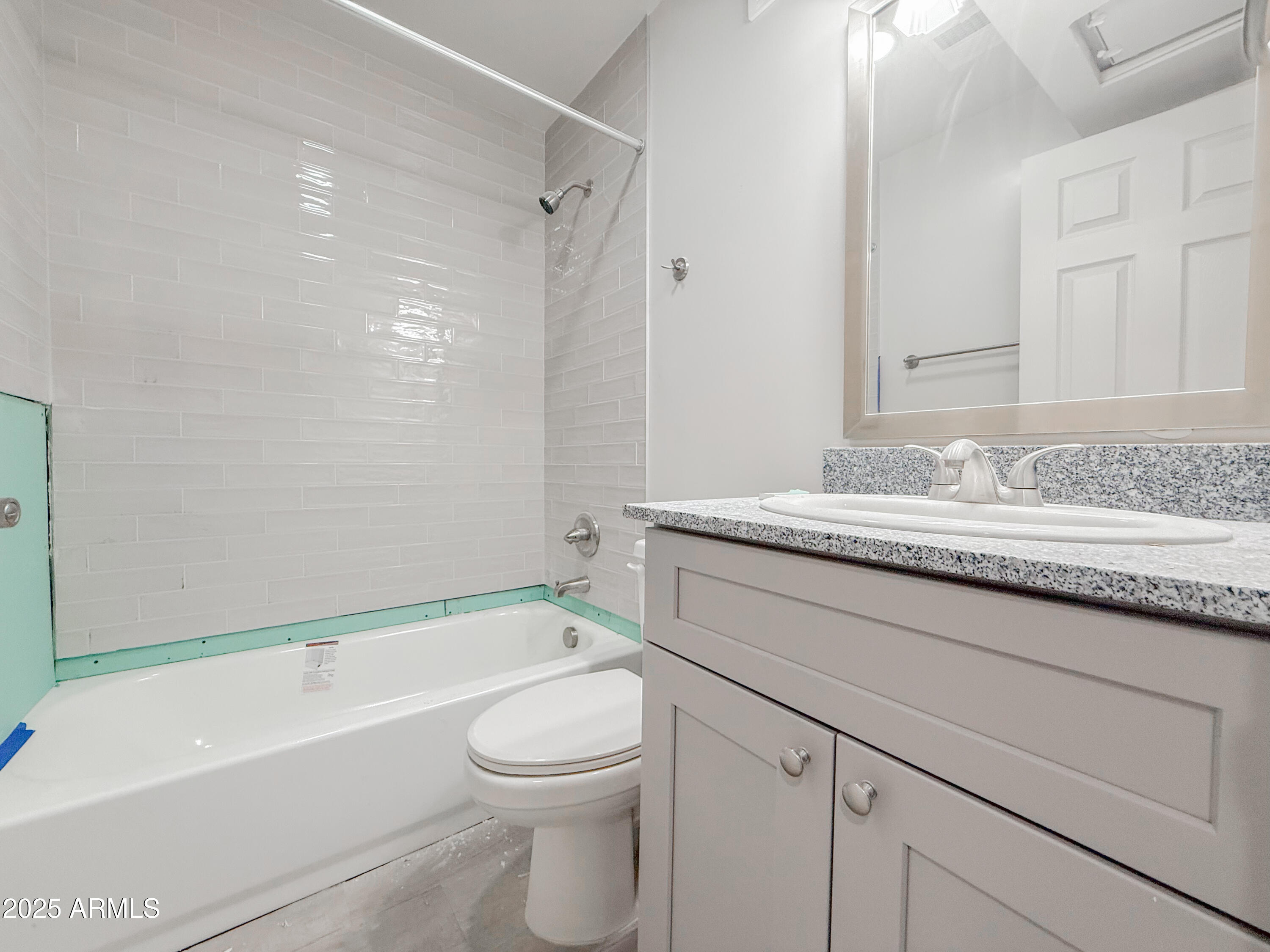 2121 West Adams Street, Unit A103 Phoenix, AZ 85009 - Photo 13 of 22 a bathroom with a granite countertop sink a toilet and bathtub