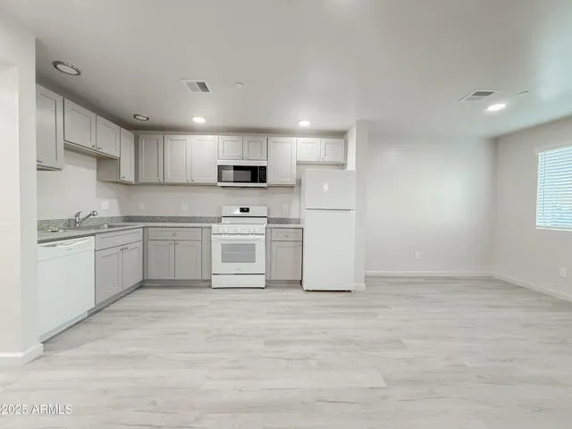 a kitchen with a refrigerator a sink and cabinets