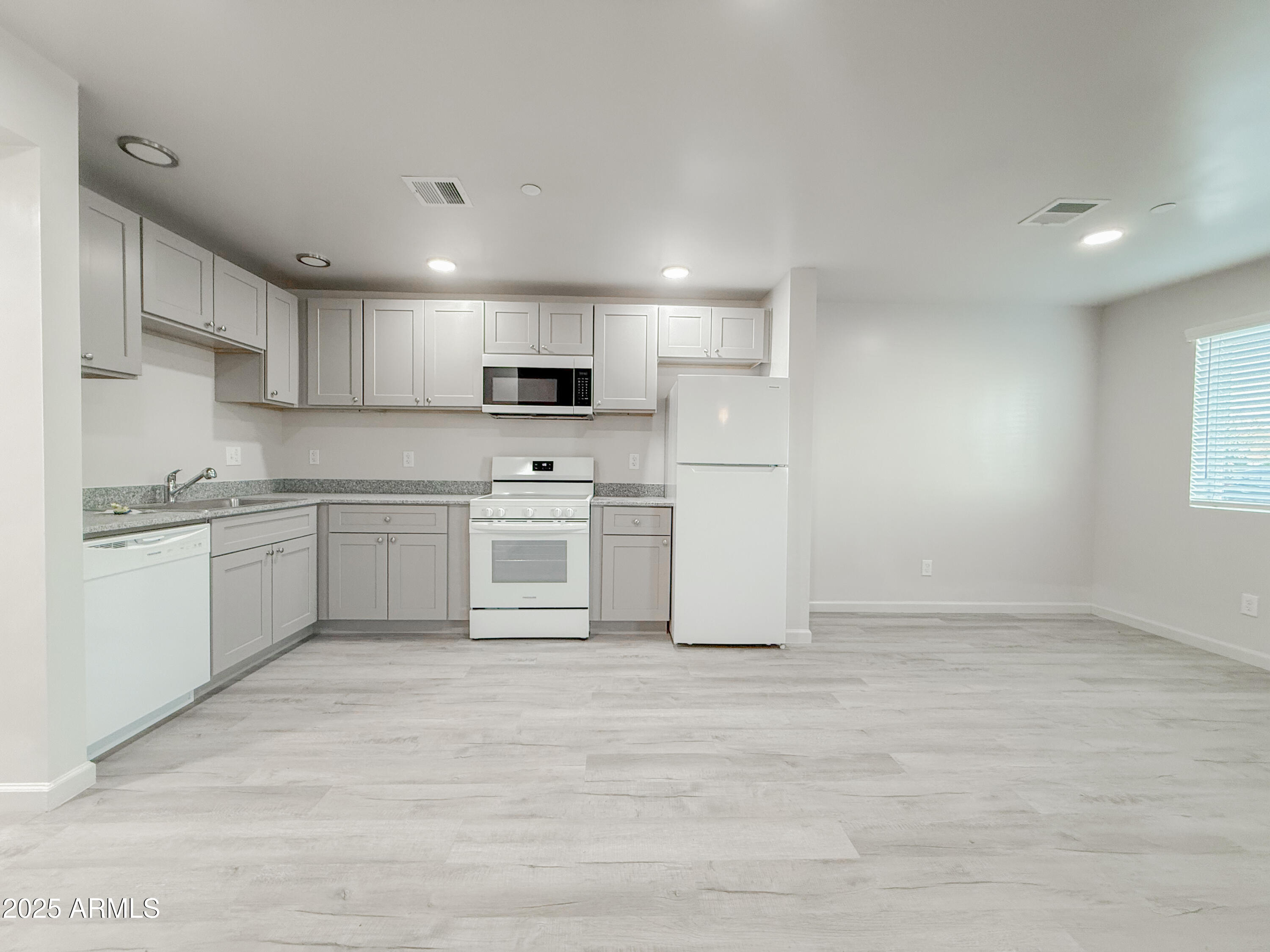 2121 West Adams Street, Unit A103 Phoenix, AZ 85009 - Photo 9 of 22 a kitchen with stainless steel appliances a refrigerator sink and cabinets