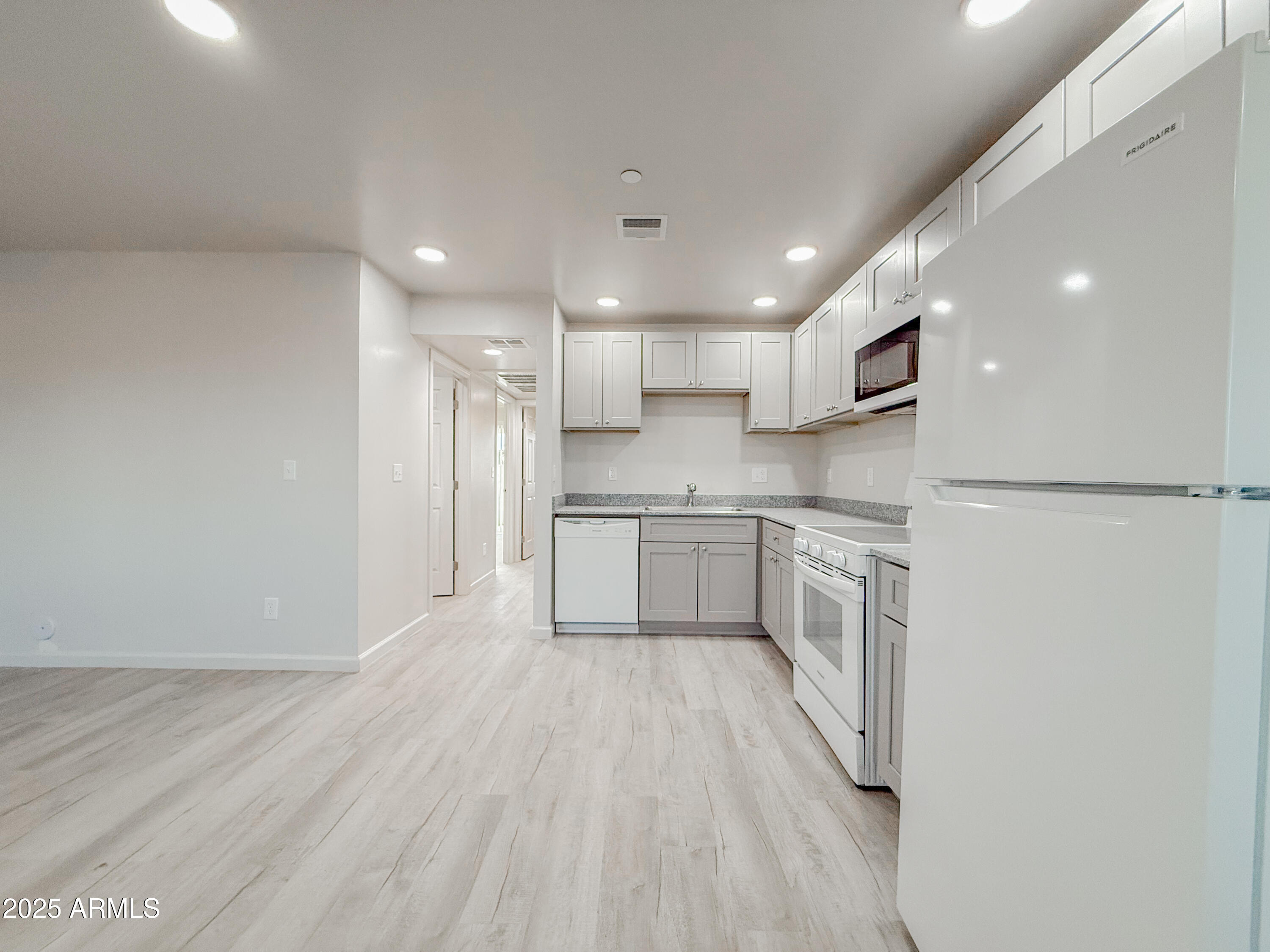 2121 West Adams Street, Unit A103 Phoenix, AZ 85009 - Photo 10 of 22 a kitchen with a refrigerator a sink and cabinets