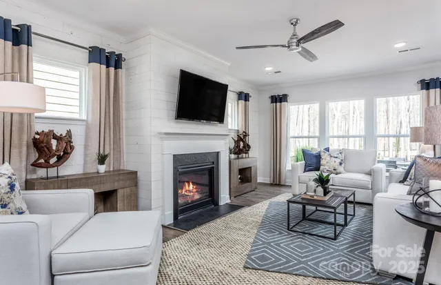 a living room with furniture a fireplace and a flat screen tv