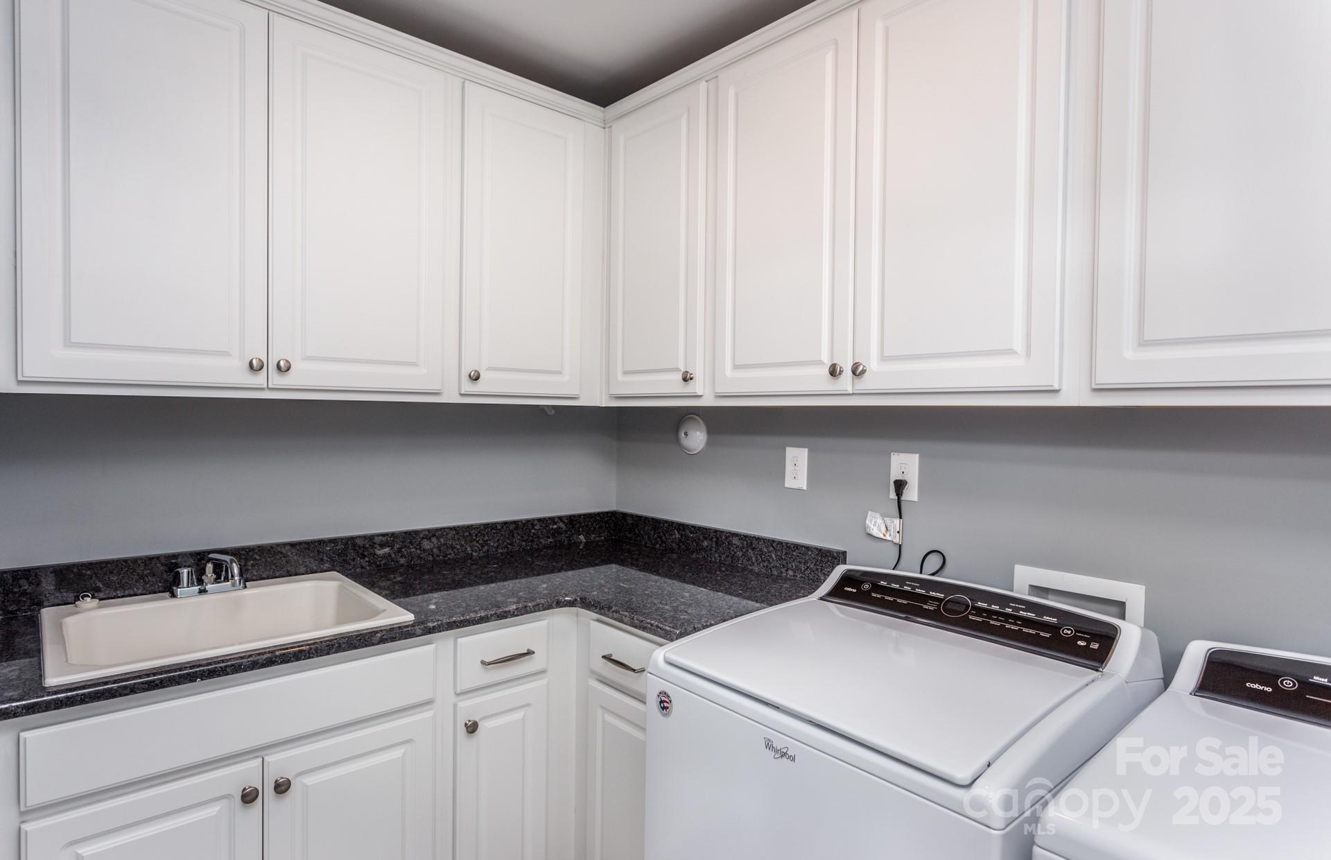 4741 Formation Court, Unit 43 Lancaster, SC 29720 - Photo 7 of 9 a utility room with granite countertop white cabinets and a stove