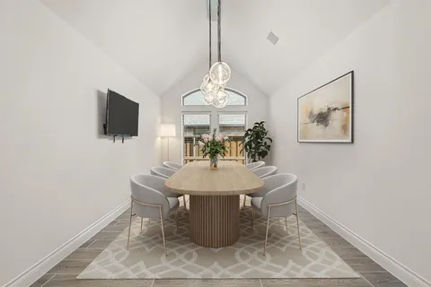 a view of an empty room with wooden floor and a fireplace