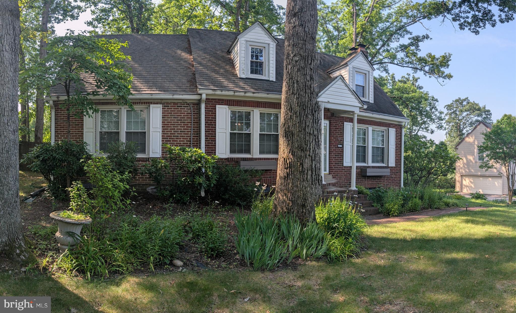 1903 Kirby Road McLean, VA 22101 - Photo 4 of 11 a view of a brick house next to a yard with plants and trees