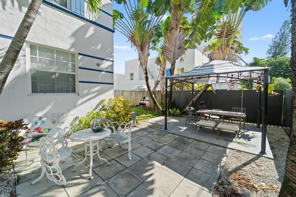 1241 13th Street, Unit 4 Miami Beach, FL 33139 - Photo 14 of 19 a view of backyard with a table and chairs and potted plants