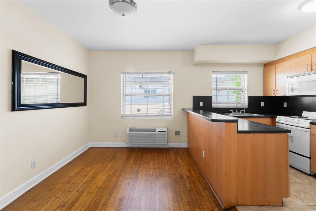 1241 13th Street, Unit 4 Miami Beach, FL 33139 - Photo 5 of 19 a kitchen with wooden floors and black appliances