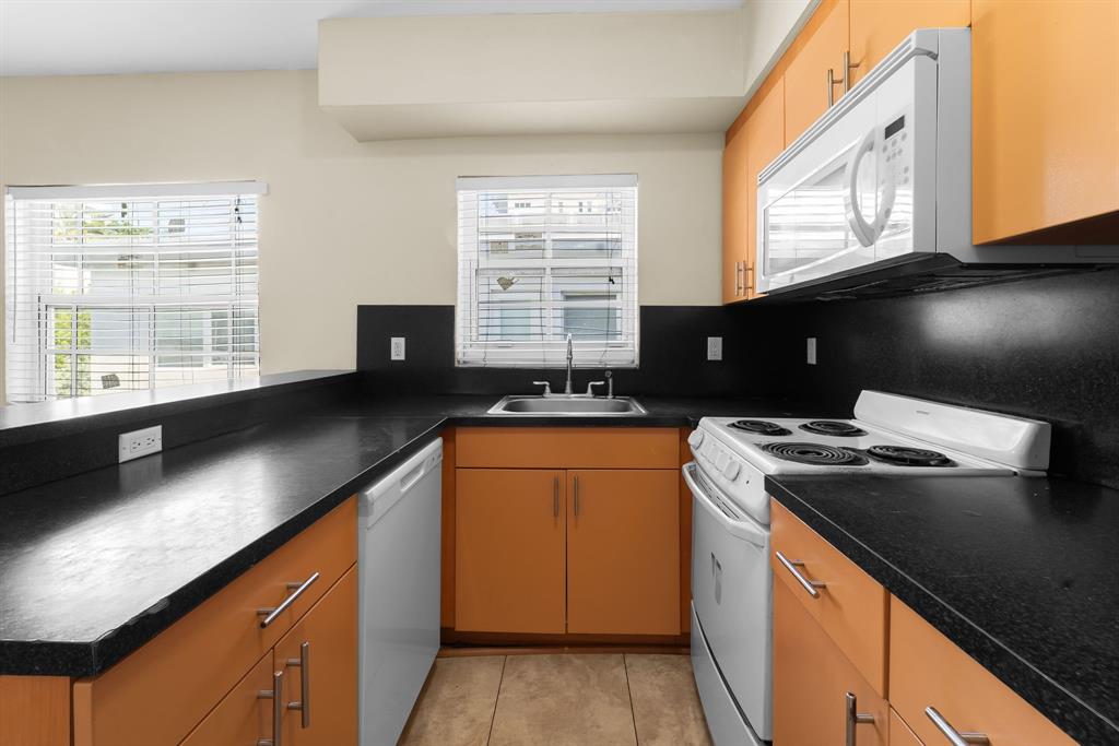 1241 13th Street, Unit 4 Miami Beach, FL 33139 - Photo 7 of 19 a kitchen with stainless steel appliances granite countertop a sink stove and cabinets