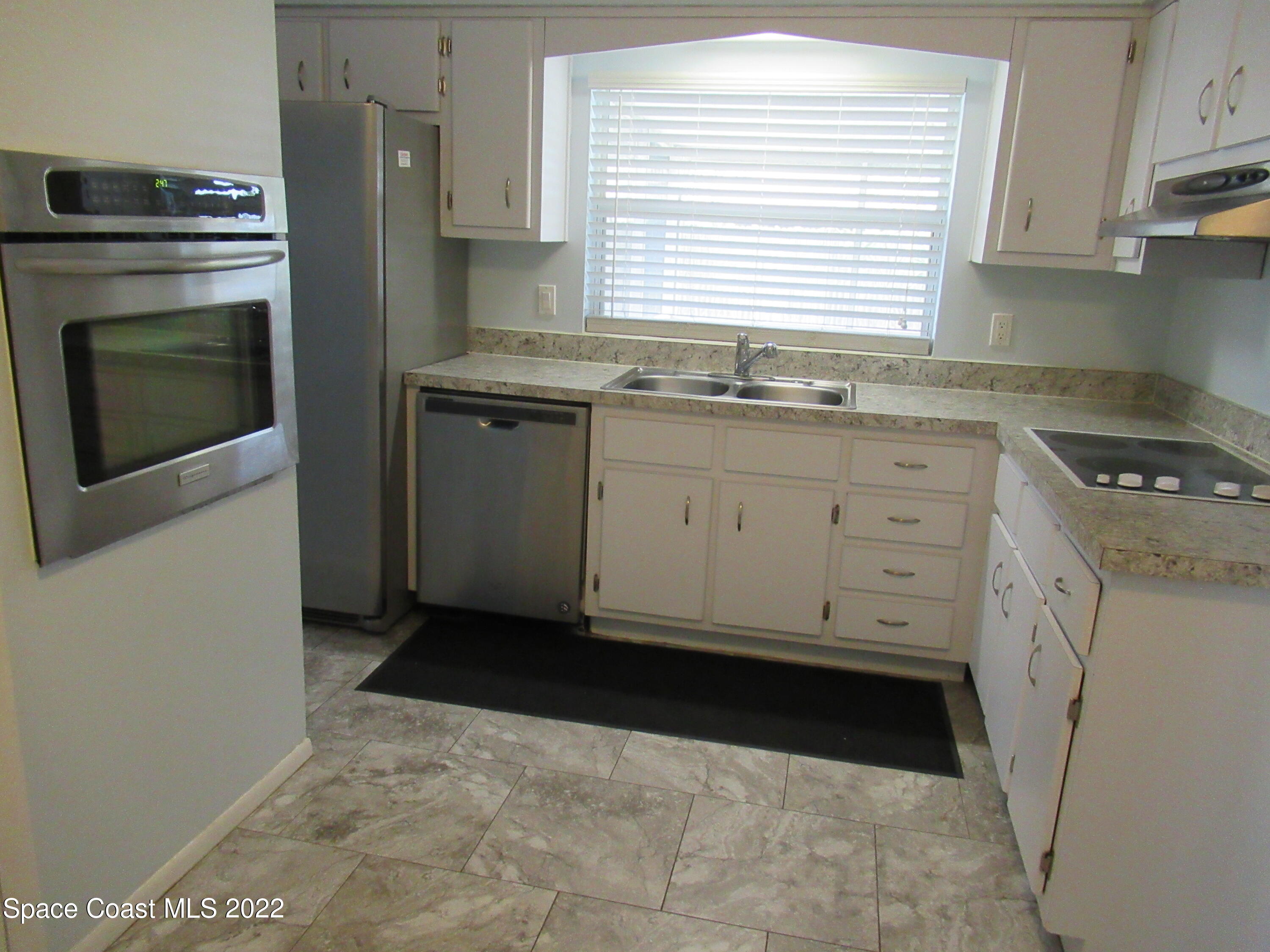 974 Bucknell Place Rockledge, FL 32955 - Photo 11 of 30 a kitchen with granite countertop a stove a washer and dryer
