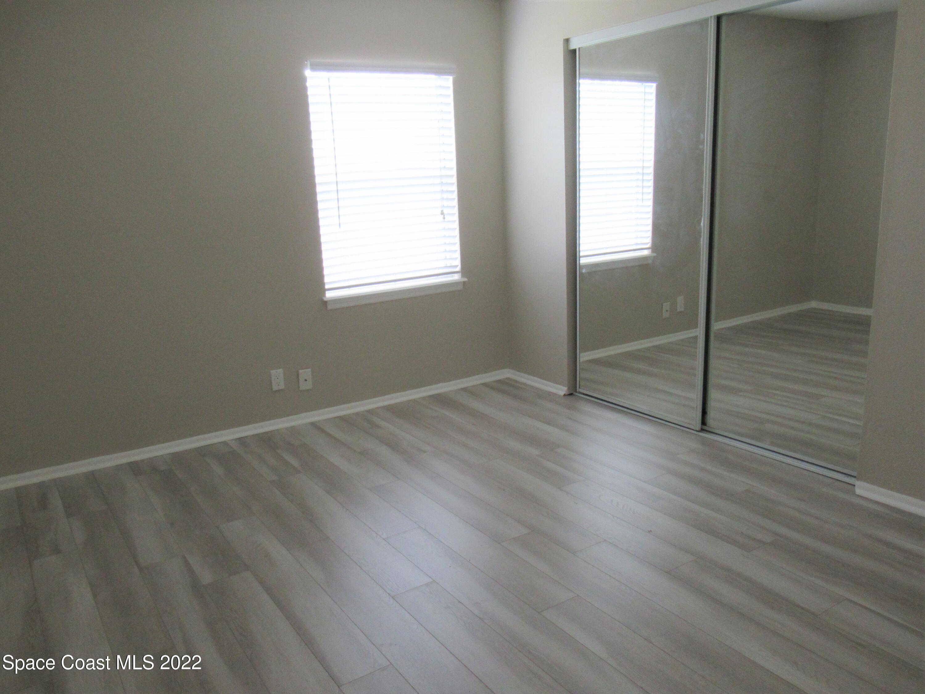 974 Bucknell Place Rockledge, FL 32955 - Photo 12 of 30 an empty room with wooden floor and windows