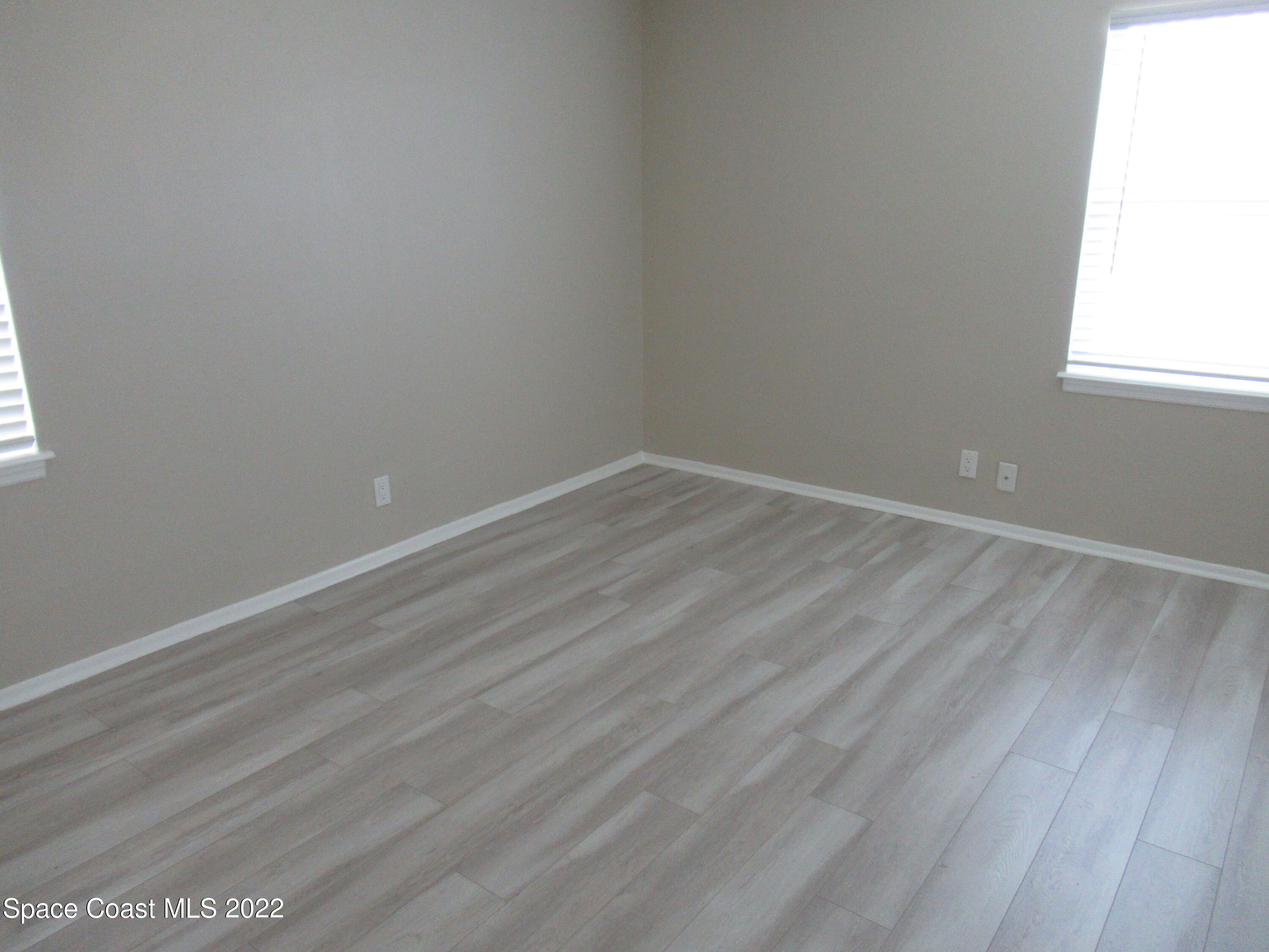 974 Bucknell Place Rockledge, FL 32955 - Photo 13 of 30 an empty room with wooden floor and windows
