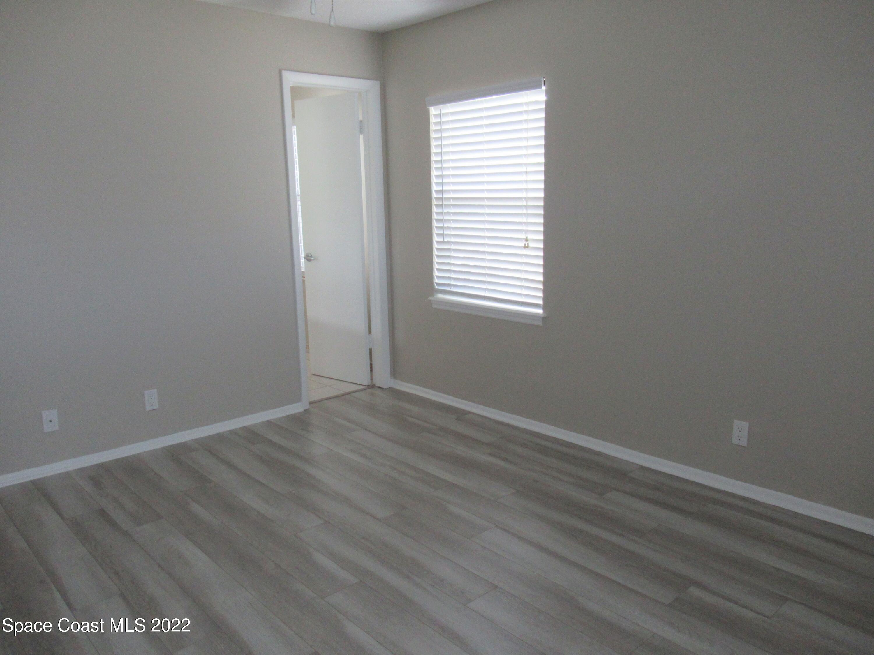 974 Bucknell Place Rockledge, FL 32955 - Photo 14 of 30 a view of an empty room with wooden floor and a window