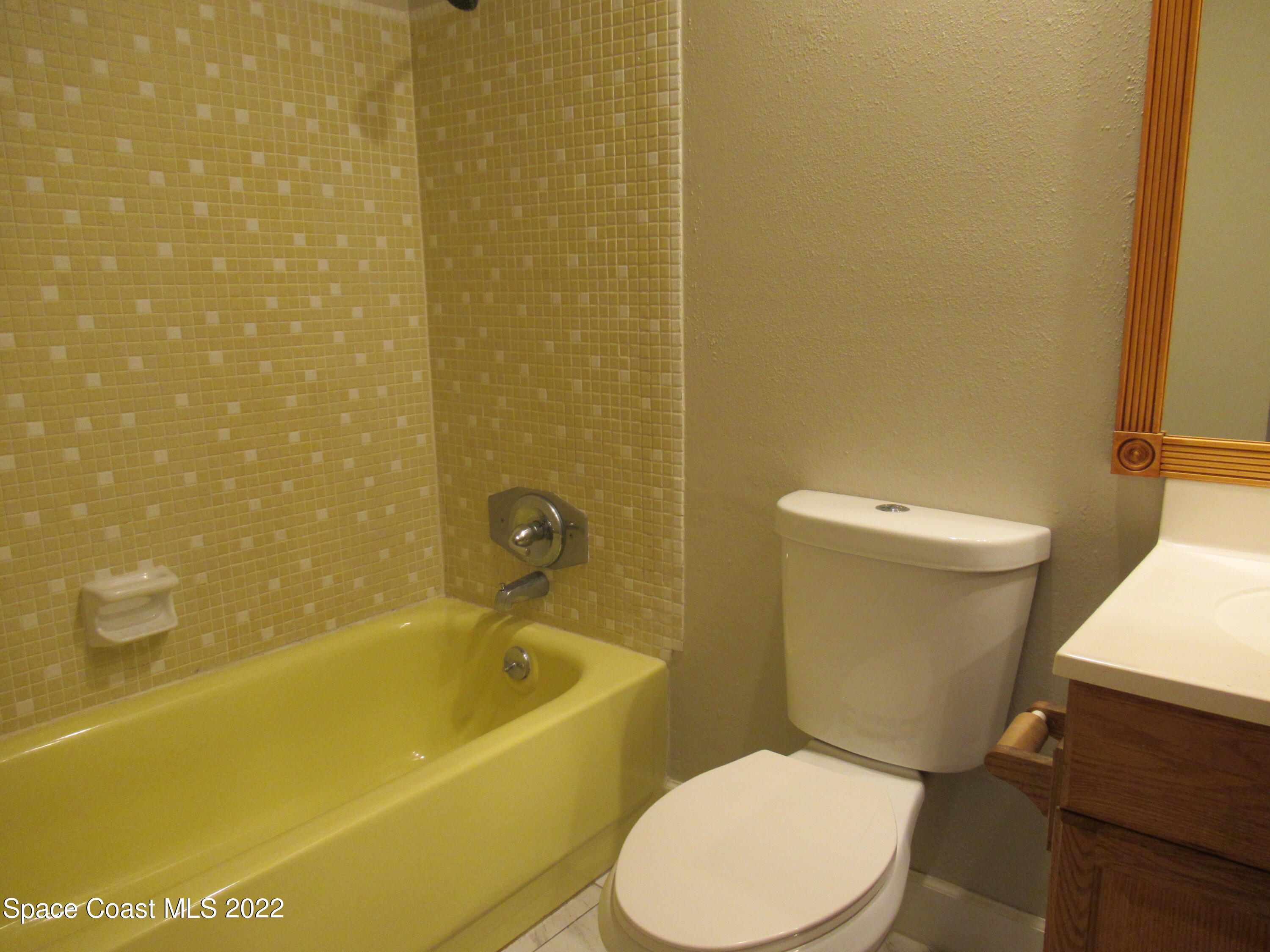 974 Bucknell Place Rockledge, FL 32955 - Photo 20 of 30 a white toilet sitting next to a bathtub