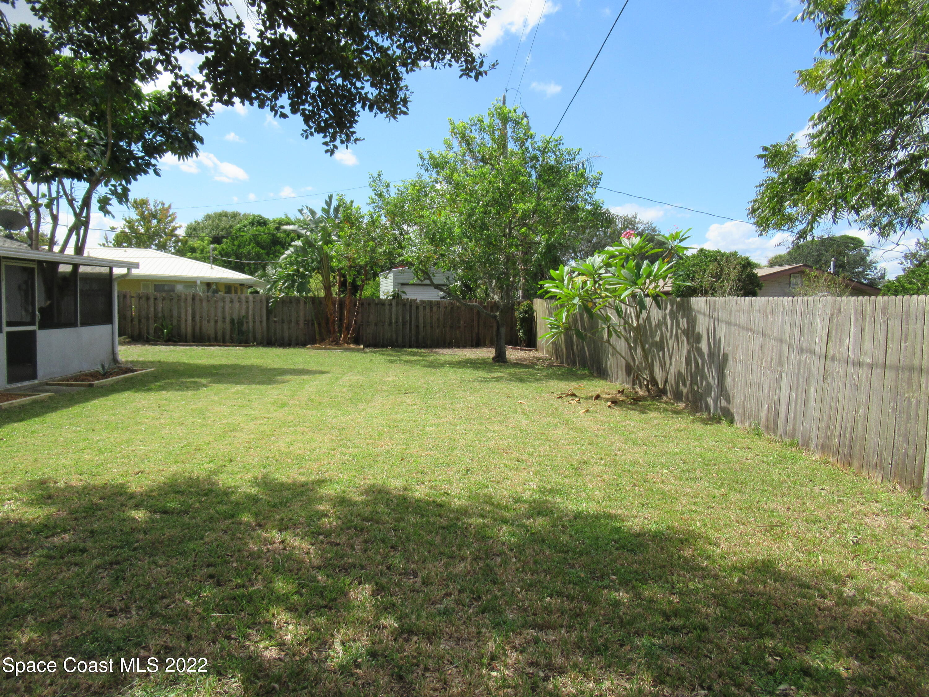 974 Bucknell Place Rockledge, FL 32955 - Photo 27 of 30 a view of a yard with a house and trees