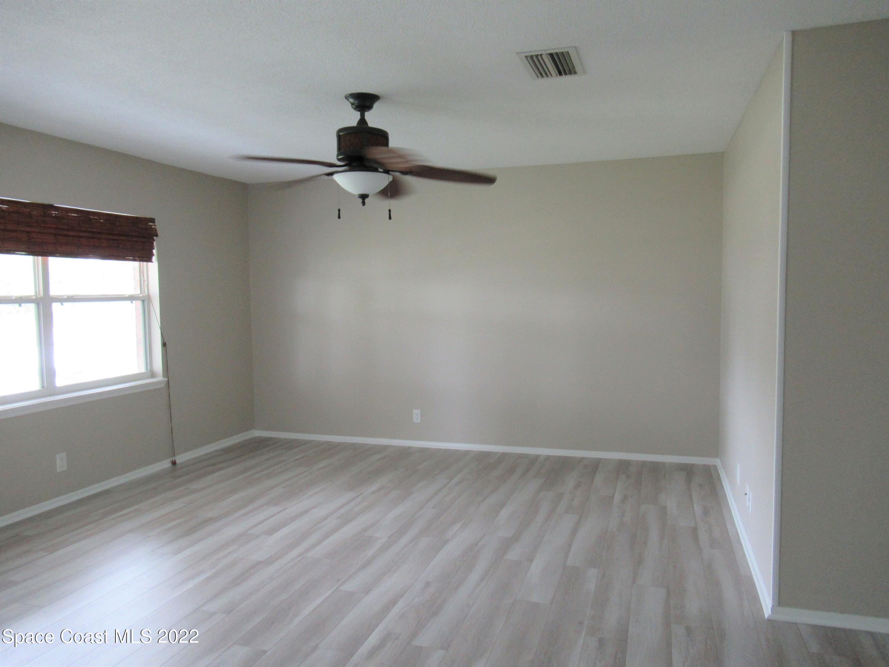 974 Bucknell Place Rockledge, FL 32955 - Photo 3 of 30 wooden floor in an empty room with a window