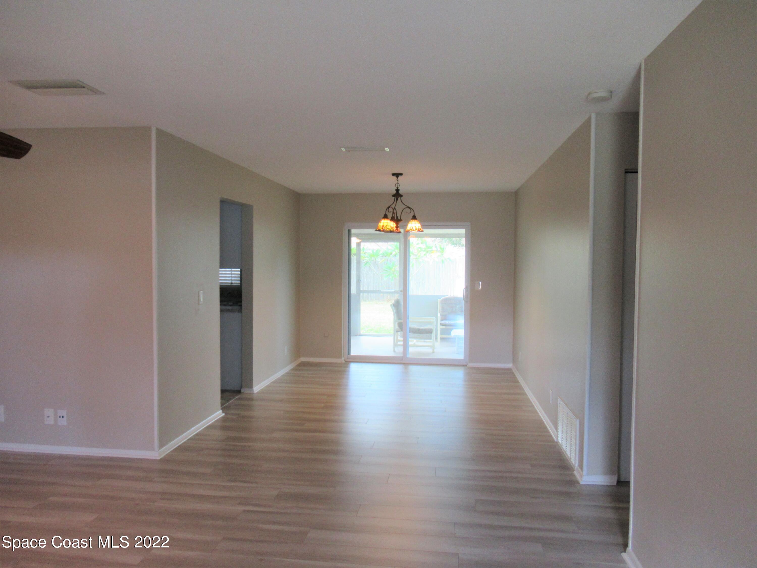974 Bucknell Place Rockledge, FL 32955 - Photo 6 of 30 a view of an empty room with wooden floor and a window