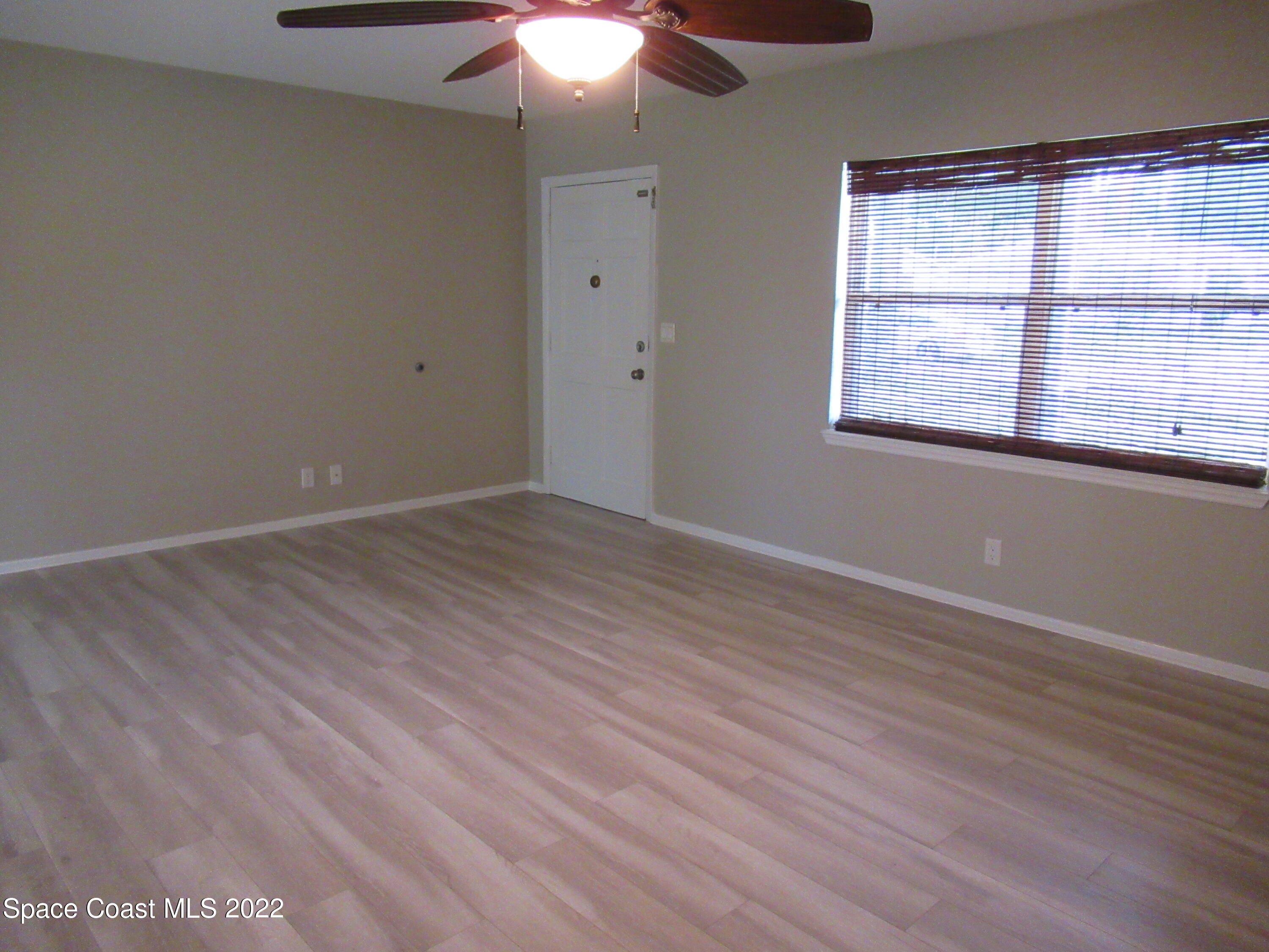 974 Bucknell Place Rockledge, FL 32955 - Photo 7 of 30 wooden floor in an empty room with a window