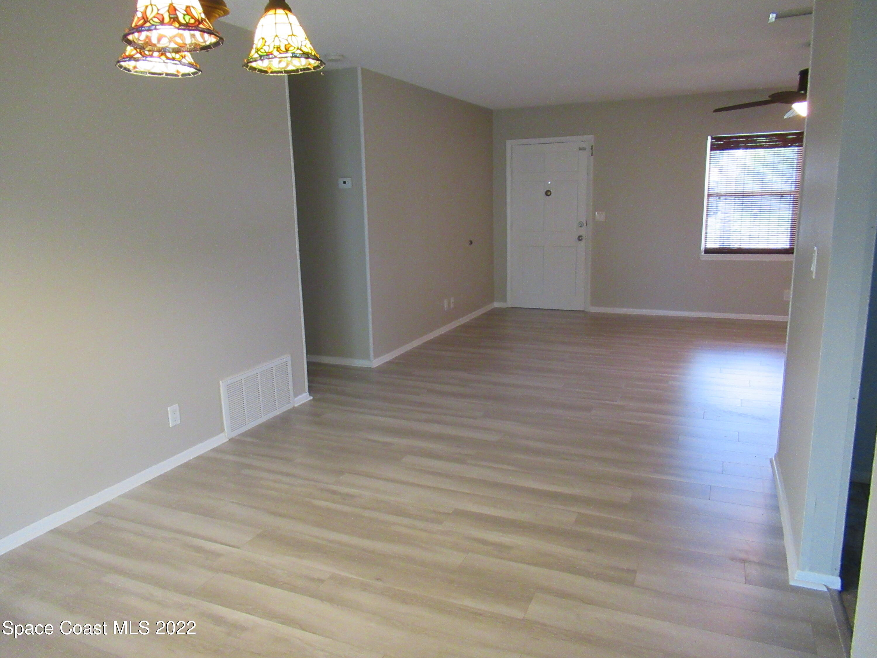 974 Bucknell Place Rockledge, FL 32955 - Photo 8 of 30 an empty room with wooden floor and windows