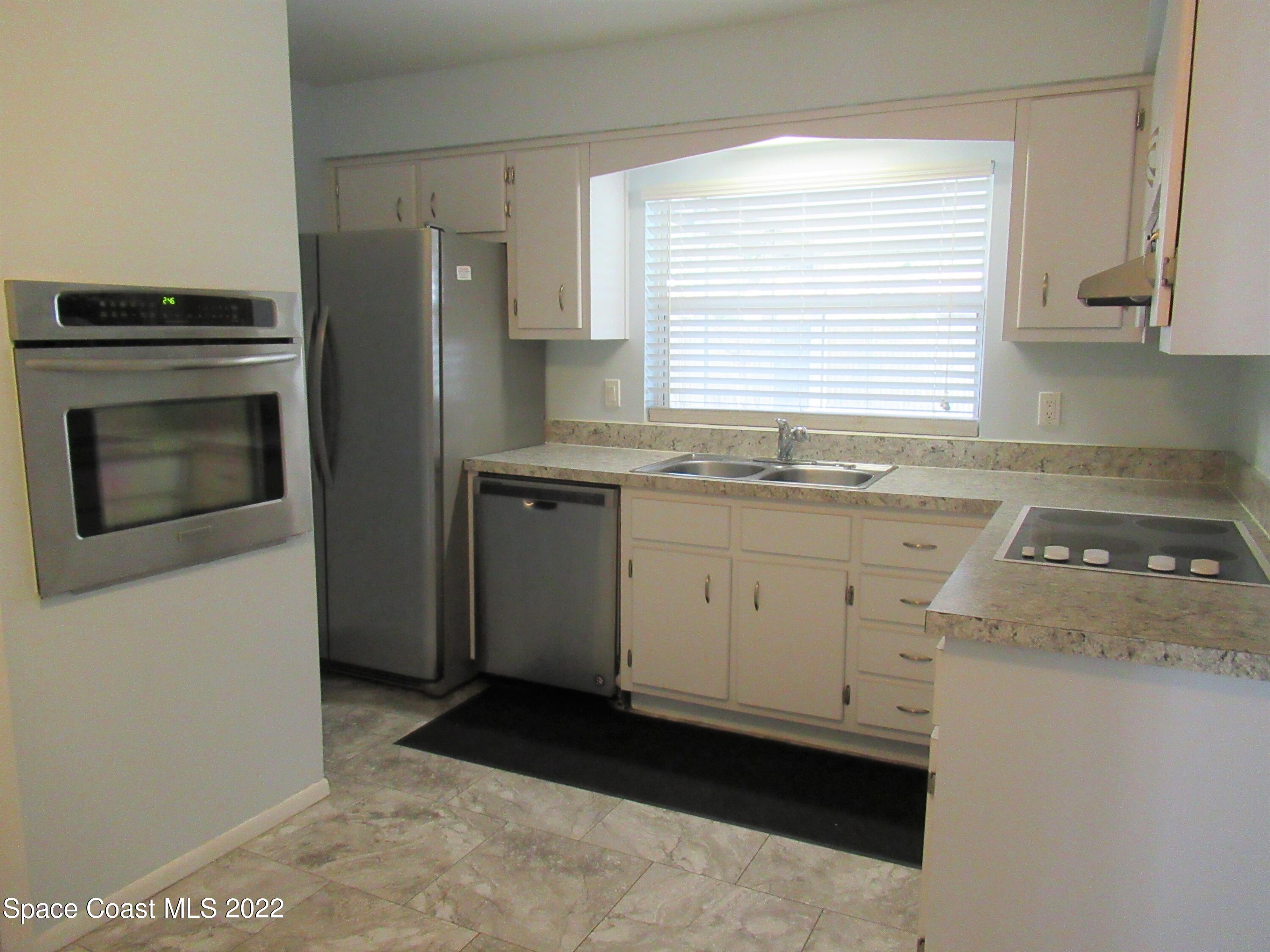 974 Bucknell Place Rockledge, FL 32955 - Photo 9 of 30 a kitchen with a sink stove and refrigerator
