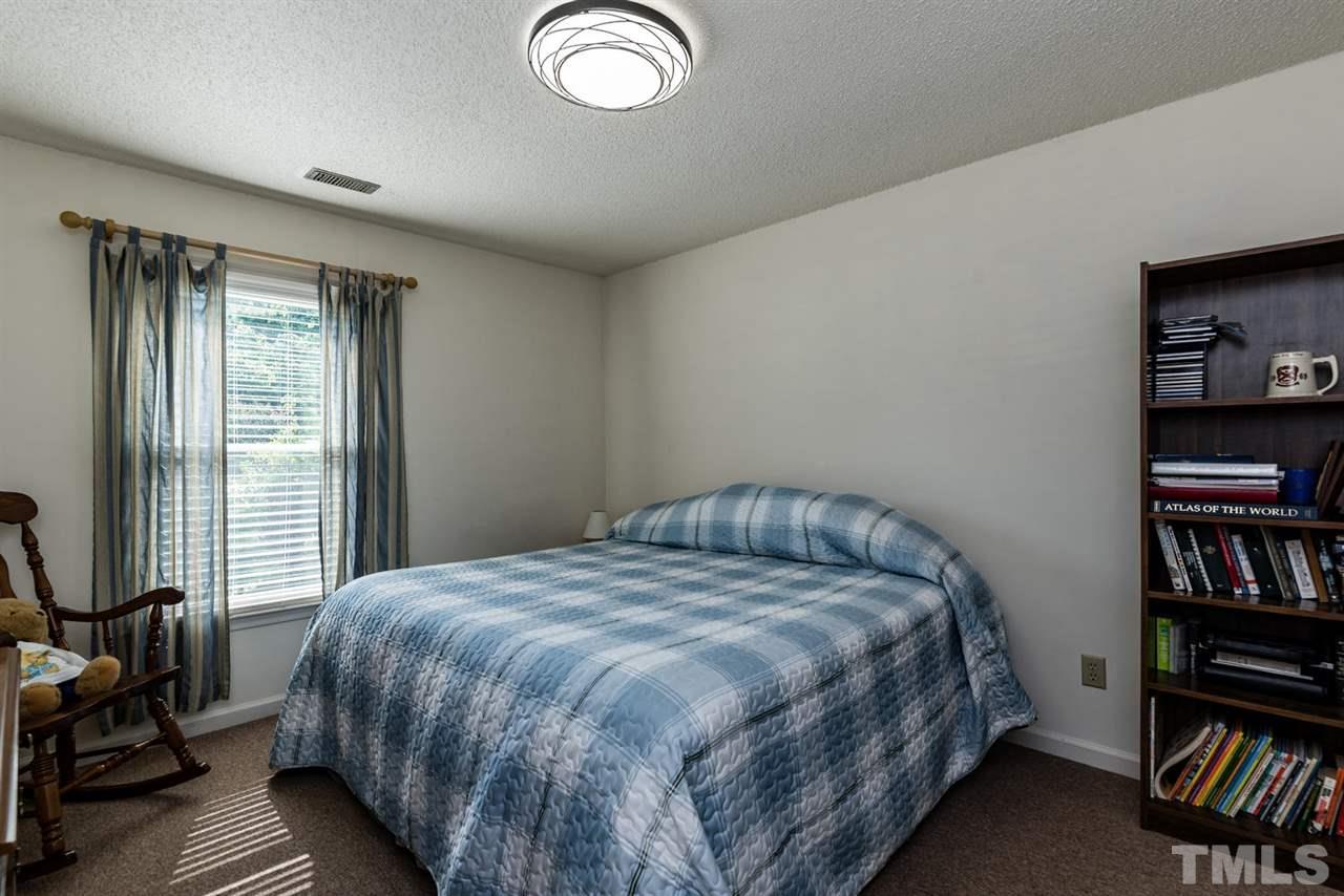 2603 Cottage Circle Raleigh, NC 27613 - Photo 20 of 25 a bedroom with a bed and a book shelf