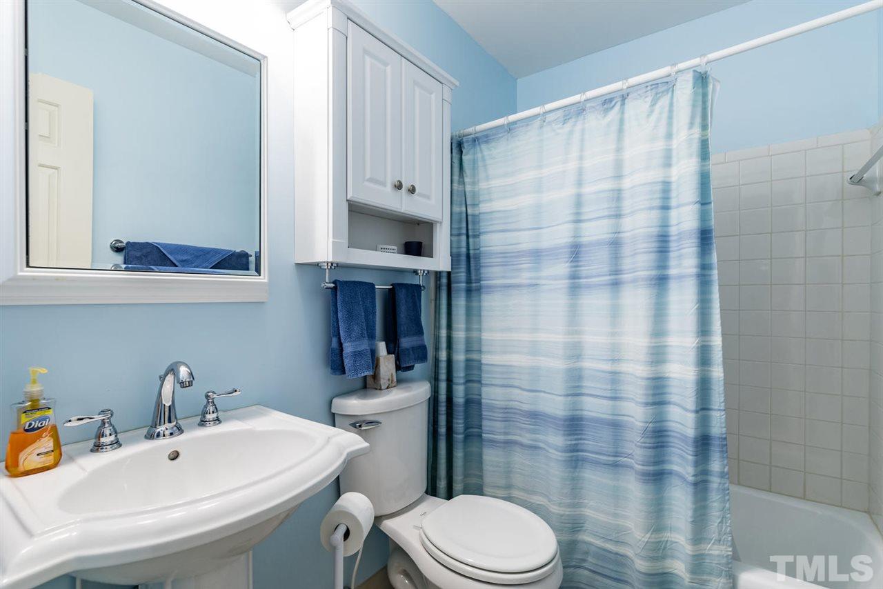 2603 Cottage Circle Raleigh, NC 27613 - Photo 22 of 25 a bathroom with a sink a toilet and shower curtain