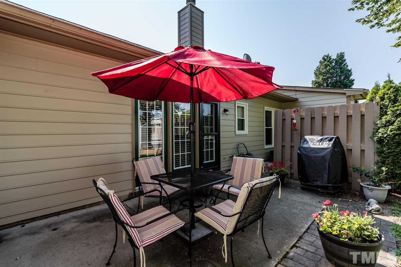 2603 Cottage Circle Raleigh, NC 27613 - Photo 23 of 25 a patio with a table and chairs under an umbrella