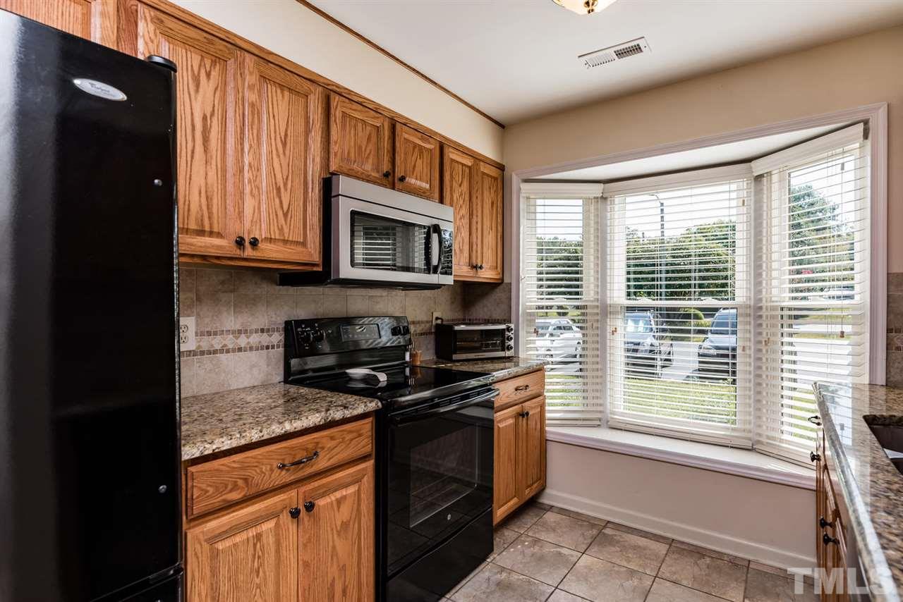 2603 Cottage Circle Raleigh, NC 27613 - Photo 7 of 25 a kitchen with stainless steel appliances granite countertop white cabinets granite counter tops and a window
