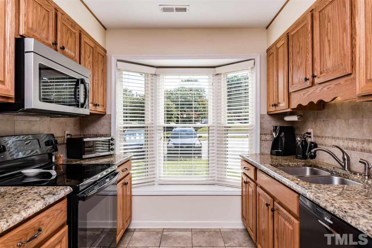 2603 Cottage Circle Raleigh, NC 27613 - Photo 9 of 25 a kitchen with stainless steel appliances granite countertop a sink stove and cabinets