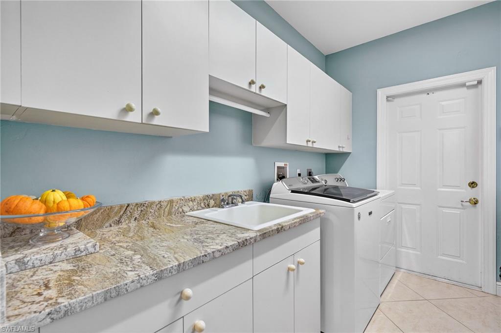 2229 Goshawk Court Naples, FL 34105 - Photo 18 of 29 a kitchen with stainless steel appliances granite countertop a sink stove and cabinets