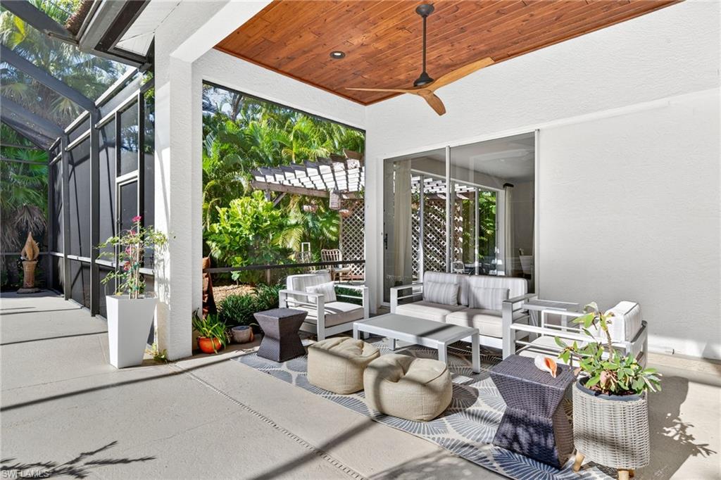 2229 Goshawk Court Naples, FL 34105 - Photo 20 of 29 a living room with patio furniture and garden view