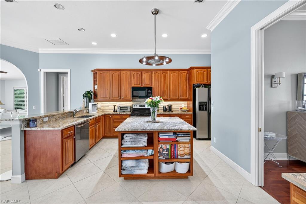 2229 Goshawk Court Naples, FL 34105 - Photo 5 of 29 a kitchen with stainless steel appliances granite countertop a stove and more cabinets